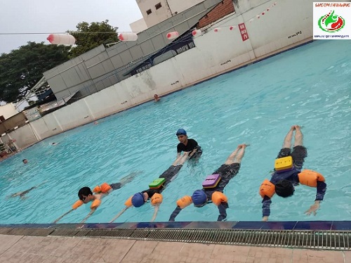Giáo viên đang hướng dẫn học viên nữ tập bơi ở TPHCM
